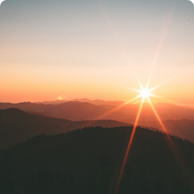 montanhas ao fundo com por do sol