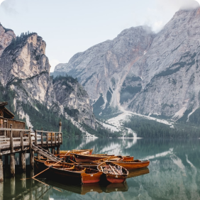 barcos em um lago com montanhas ao fundo